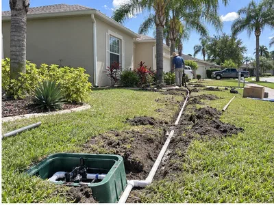 New white irrigation lines and valve box being installed across an ordinary Central Florida front yard